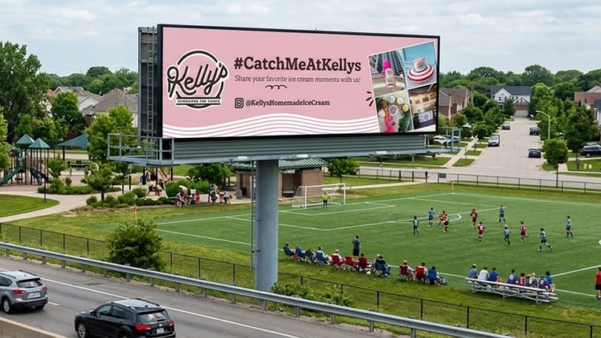 Digital billboard overlooking a residential highway showing a Kelly's Homemade Ice Cream social media hashtag campaign